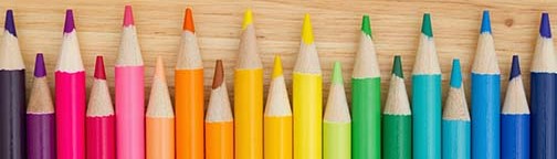 Open House text with colorful pencil crayons on a desk